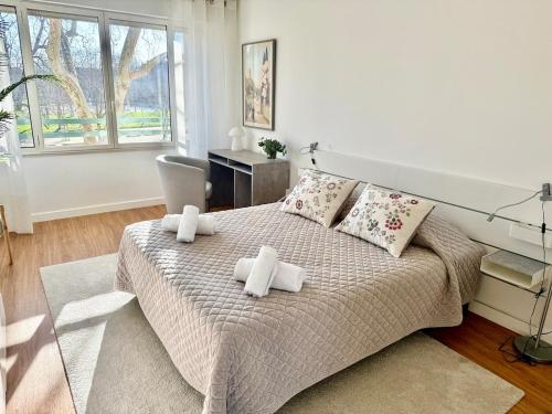 une chambre avec un grand lit avec des serviettes dessus dans l'établissement Le Dandy de la Fontaine climatisation et garage, à Nîmes