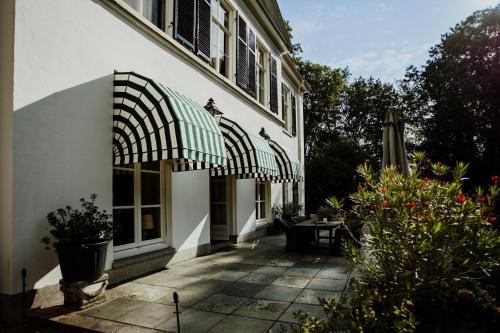 a house with an awning on the side of it at Landgoed Loenen B&B in Slijk-Ewijk