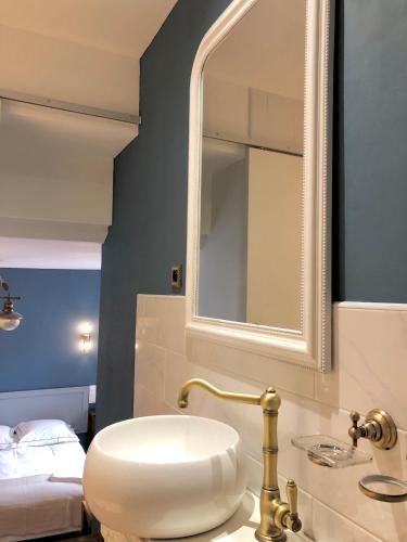 a bathroom with a sink and a mirror and a bed at Hôtel D’Artiste in Pierrefontaine-les-Varans