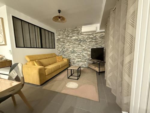 un salon avec un canapé et une télévision dans l'établissement SINT Cannes T 1, à Cannes