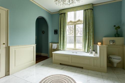 a bathroom with a toilet and a window at Landgoed Loenen B&B in Slijk-Ewijk
