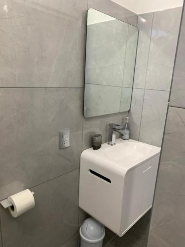 a white bathroom with a sink and a mirror at Casa GALLARDO in Manzanillo