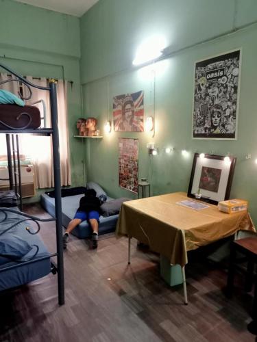 a person laying on a bed in a room with a table at Bang lumphu house&bistro in Bangkok