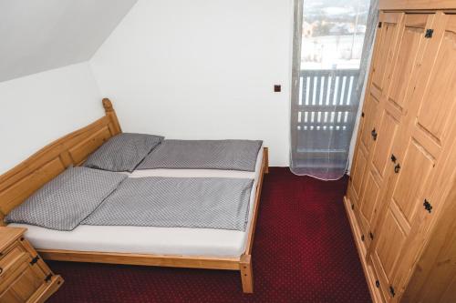 a bedroom with a bed and a window and a door at wellness Chata u Pinkasů in Písečná