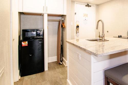 a kitchen with a black refrigerator and a sink at Tropical Suite at Oceanfront Resort w Lazy River in Myrtle Beach