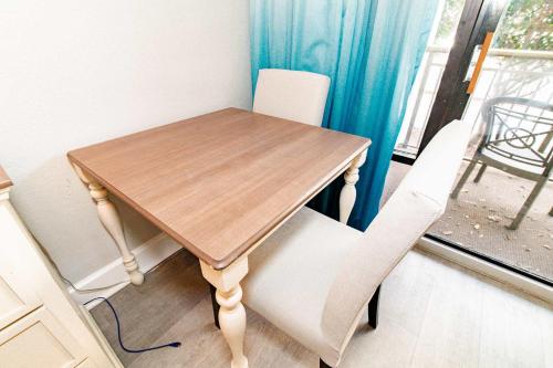 a wooden table and two white chairs next to a window at Tropical Suite at Oceanfront Resort w Lazy River in Myrtle Beach