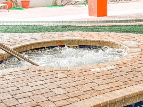 a circular pool of water in a brick patio at Tropical Suite at Oceanfront Resort w Lazy River in Myrtle Beach