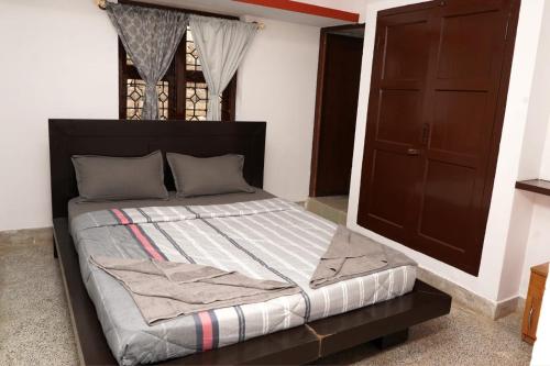 a bedroom with a bed with a wooden headboard at Lands End in Madikeri