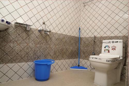 a bathroom with a toilet and a blue bucket at Lands End in Madikeri