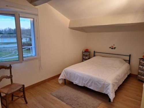 une chambre avec un lit et une fenêtre dans l'établissement Loue charmante petite maison dans un écrin de verdure, à Saint-Vivien-de-Médoc