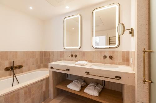a bathroom with a sink and a tub and a mirror at Ostuni a Mare in Ostuni