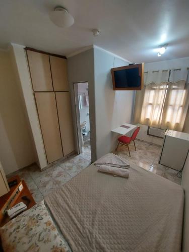a bedroom with a bed and a desk and a table at Hotel Mooca in Sao Paulo