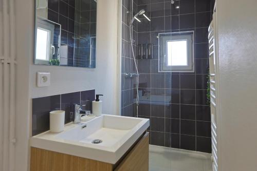 une salle de bain avec un lavabo et une douche dans l'établissement La Cachette Centre-Ville, à Saint-Étienne