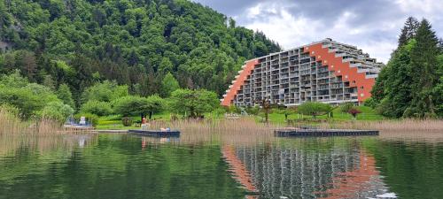 a large building next to a body of water at Direkter Seezugang am Ossiacher See, Radfahren, Wandern & Erlebniscard in Villach