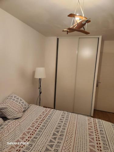une chambre avec un lit et un ventilateur de plafond dans l'établissement Chic et simple avec parking à 5 min de la gare, à Nantes