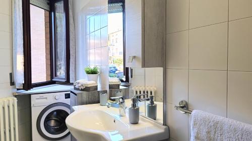 a bathroom with a sink and a washing machine at MITO Sea Apartment in Porto San Giorgio