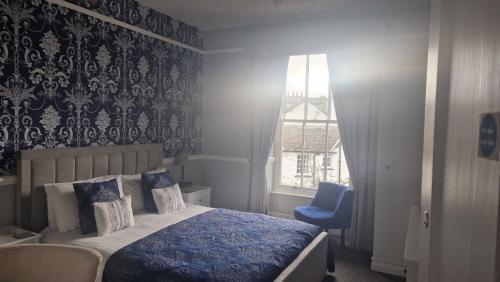 a bedroom with a bed and a blue chair at New Hall Bank in Bowness-on-Windermere
