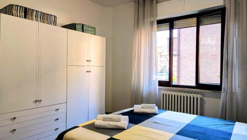 a bedroom with a bed and a cabinet and windows at MITO Sea Apartment in Porto San Giorgio
