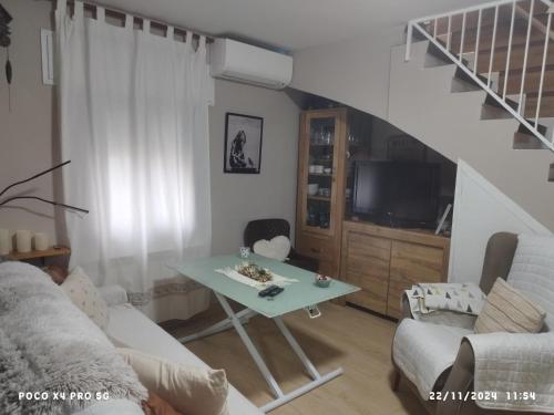 a living room with a table and a staircase at CASA GORDON in Navaluenga