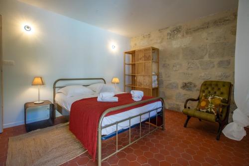 une chambre avec un grand lit et une chaise dans l'établissement Oasis secrète Avignon 6 personnes, à Avignon