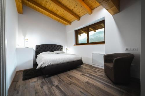 a bedroom with a bed and a chair at Le Coin Du Bois Chambre d'Hotes in Nus