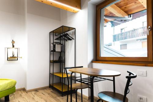 a table and chairs in a room with a window at Le Coin Du Bois Chambre d'Hotes in Nus