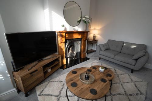 a living room with a television and a coffee table at 4 Bed End Terrace - sleeps 7 in Ilkley