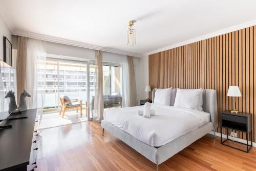 une chambre avec un grand lit blanc et un bureau dans l'établissement Luxurious Apartment with Sea and Carlton View, à Cannes