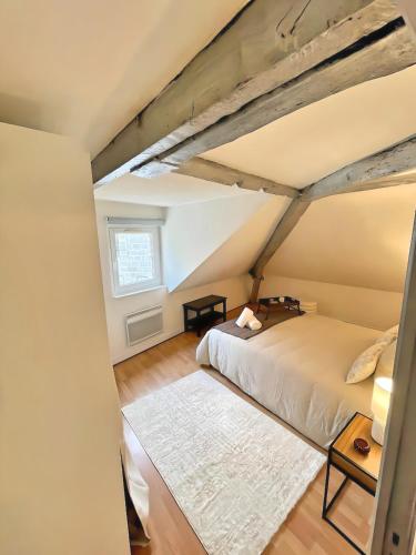 a bedroom with a bed and a window at La Mansarde - Cœur Historique, Charme et Confort in Brive-la-Gaillarde