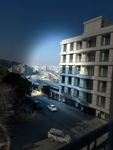 a street with cars parked in front of a building at Madina-ZamZam Halal Hotels Group in Baku