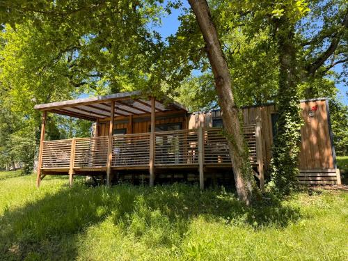a wooden house in a field with a tree at Whaka Lodge in Seissan