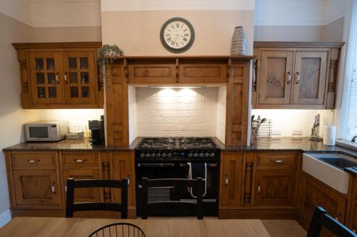 a kitchen with wooden cabinets and a stove top oven at 4 Bed End Terrace - sleeps 7 in Ilkley