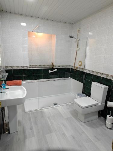 a bathroom with a tub and a toilet and a sink at The Jays Guest House in Aberdeen