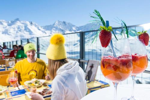 a man and a woman sitting at a table with strawberries in a wine glass at Ferienwohnung Stelzis in Wald am Arlberg
