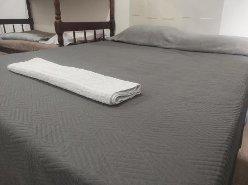 a white towel sitting on top of a bed at 2 Quartos amplos Completo com Internet Garagem e Ar condicionado in Paranaguá