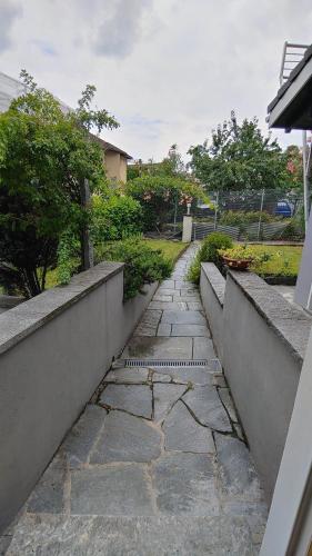 a stone walkway in a yard with a fence at Il Baitone 1 in Minusio