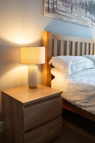 a lamp on a night stand next to a bed at 4 Bed End Terrace - sleeps 7 in Ilkley