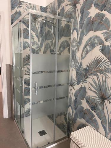 a shower stall in a room with a tropical wallpaper at la perla in Nettuno