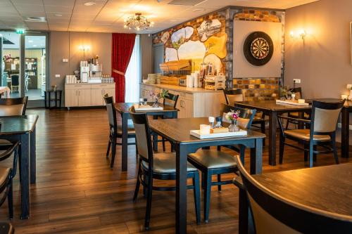 a dining room with tables and chairs in a restaurant at Hof van Putten in Putten