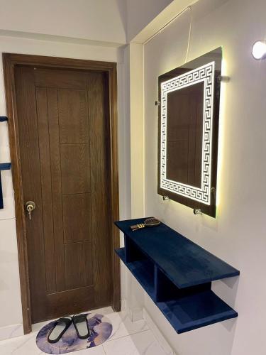 a bathroom with a blue shelf and a mirror at Beachfront Studios by Virani in Karachi