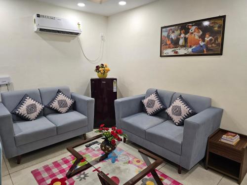 a living room with two couches and a air conditioner at Ultra Luxury 1Bhk 1121 Flat By Bliss Stay in Ghaggar