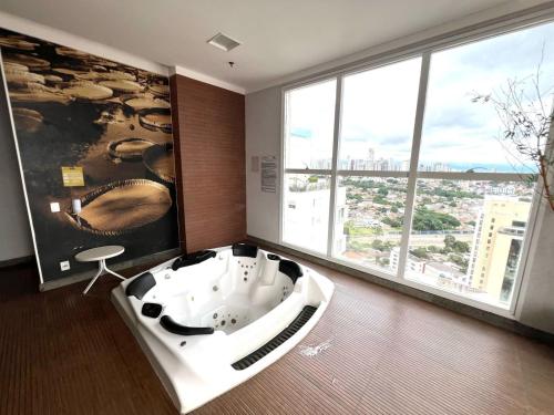 una vasca da bagno in una stanza con una grande finestra di #2006B# Apto 1 quarto Metropolitan Barcelona a Goiânia