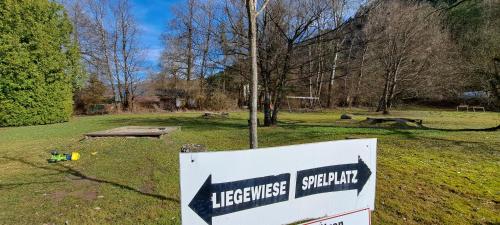 a sign in the middle of a grass field at Direkter Seezugang am Ossiacher See, Radfahren, Wandern & Erlebniscard in Villach