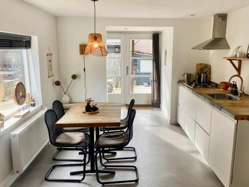 a kitchen with a wooden table and chairs at ZILT sous in Noordwijk