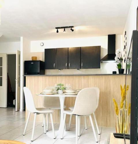 une cuisine avec une table et des chaises dans une pièce dans l'établissement Rodger villa, à Perpignan