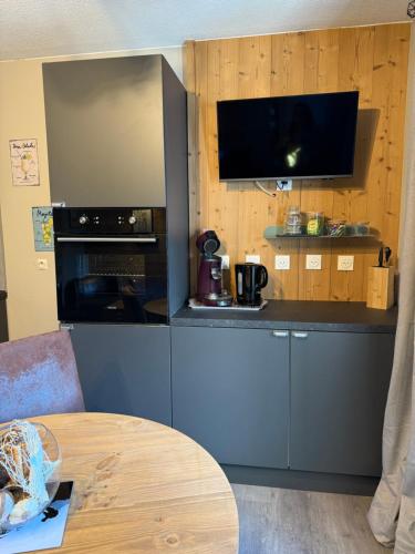 - une cuisine avec un comptoir, une cuisinière et une table dans l'établissement Logement cosy à la montagne, à Bourg-Saint-Maurice