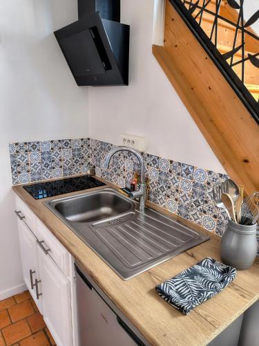 une cuisine avec un évier et un plan de travail dans l'établissement Maison de campagne, Gîte rouge, à Brigné