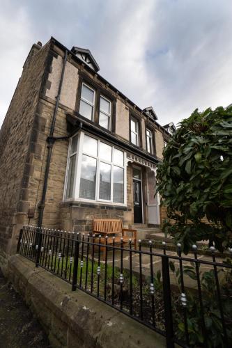 a brick house with a bench in front of it at 4 Bed End Terrace - sleeps 7 in Ilkley