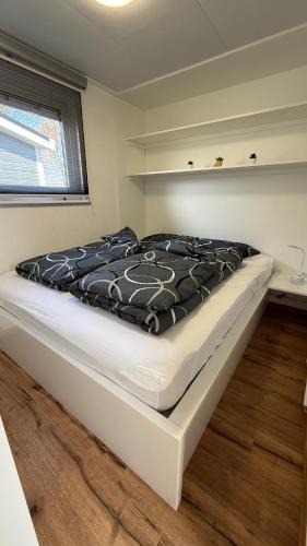 a large bed in a room with a white mattress at Chalet am Rhederlaag in Lathum