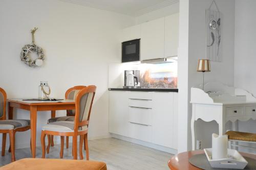 a kitchen and dining room with a table and chairs at Appartement-Villa Steinfurth in Binz